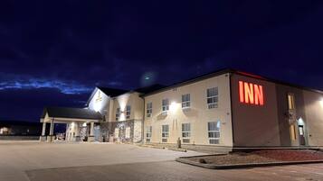 A hotel with a prominent 'INN' sign, a covered entrance, and a parking lot.