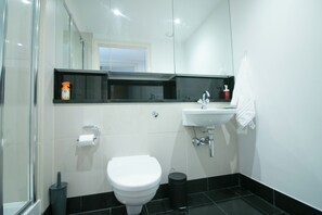 A modern bathroom with a toilet, sink, and shower area. - Lux Modern 2BR Flat wth Balcony • Walk to Battersea Park, River, Mall, Transport (London)