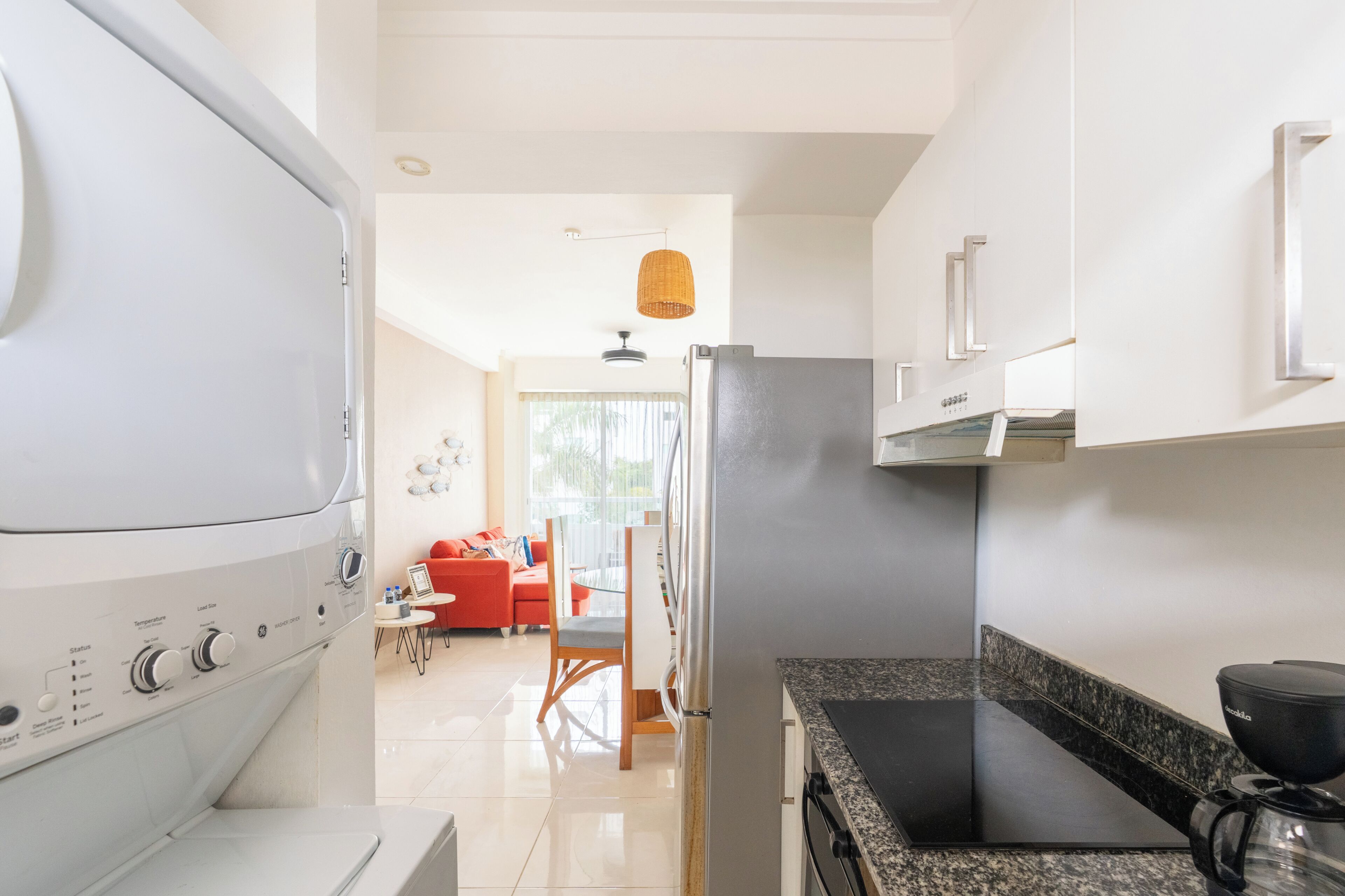 Una cocina moderna con horno integrado, refrigerador y cafetera.