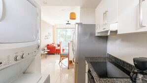 Una cocina moderna con horno integrado, refrigerador y cafetera.