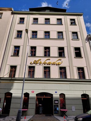 Ein mehrstöckiges Gebäude mit einem auffälligen Schild, auf dem 'Arkadia' steht.