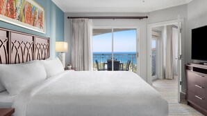 A hotel room with a large bed, a TV, a balcony with a view of the sea, and a painting on the wall. - OCEANFRONT- Beautiful 2 Bedroom-Marriott's Aruba Surf Club - Full Resort Access (Noord)