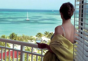 A person overlooking a coastal view with a sailboat on the water. - Rare OCEANFRONT- Beautiful 2 Bed-Marriott Aruba Surf Club - Full Resort Access (Noord)