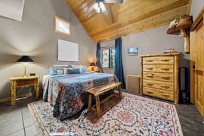 A bedroom with a bed, a wooden dresser, a bench, a desk, and a window with curtains. - Trade the Heat for the Pines: Pinetop Family Cabin, Kayaks & Cool Nights (Pinetop)
