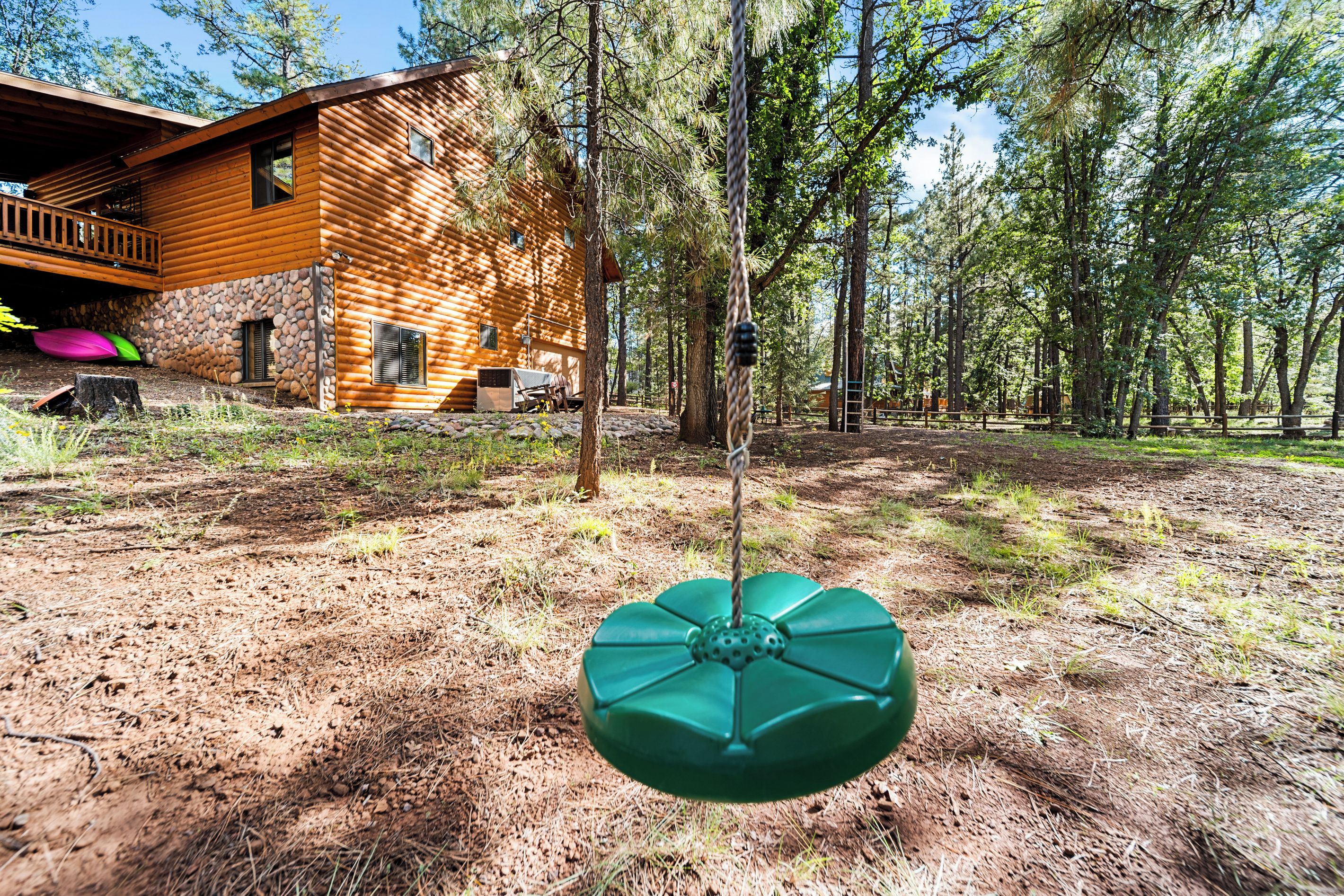 A wooden cabin with a stone foundation, surrounded by a forest.