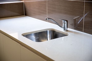 A kitchen sink with a stainless steel basin and a modern faucet. - Bondi Beach Studio | Private Balcony & Kitchen (Bondi Beach)