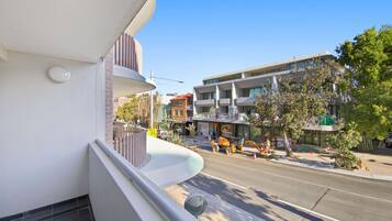 Un edificio moderno con un balcone che si affaccia su una strada.