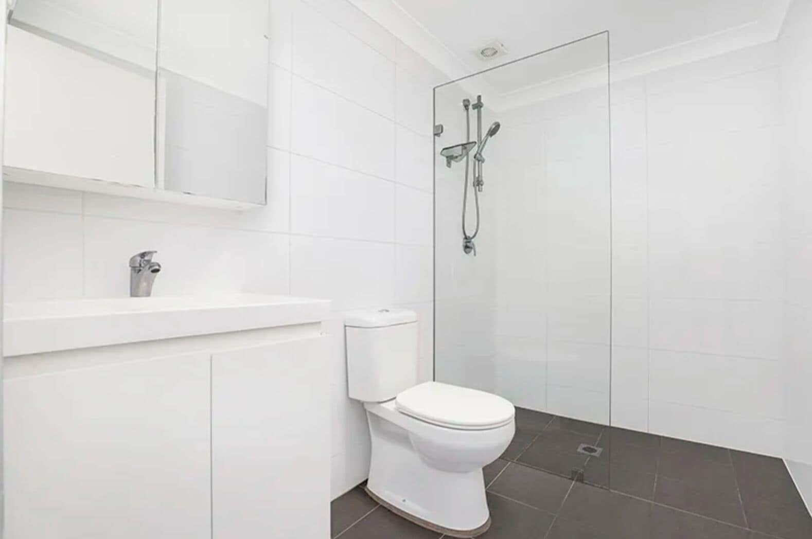 Une salle de bain moderne équipée de toilettes, d’un lavabo et d’une douche.