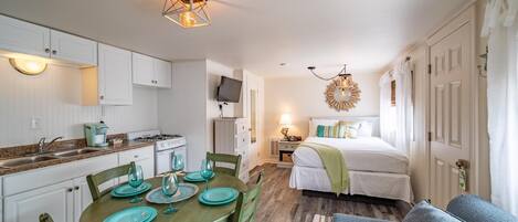 A compact living space with a kitchen, dining area, and a bedroom.