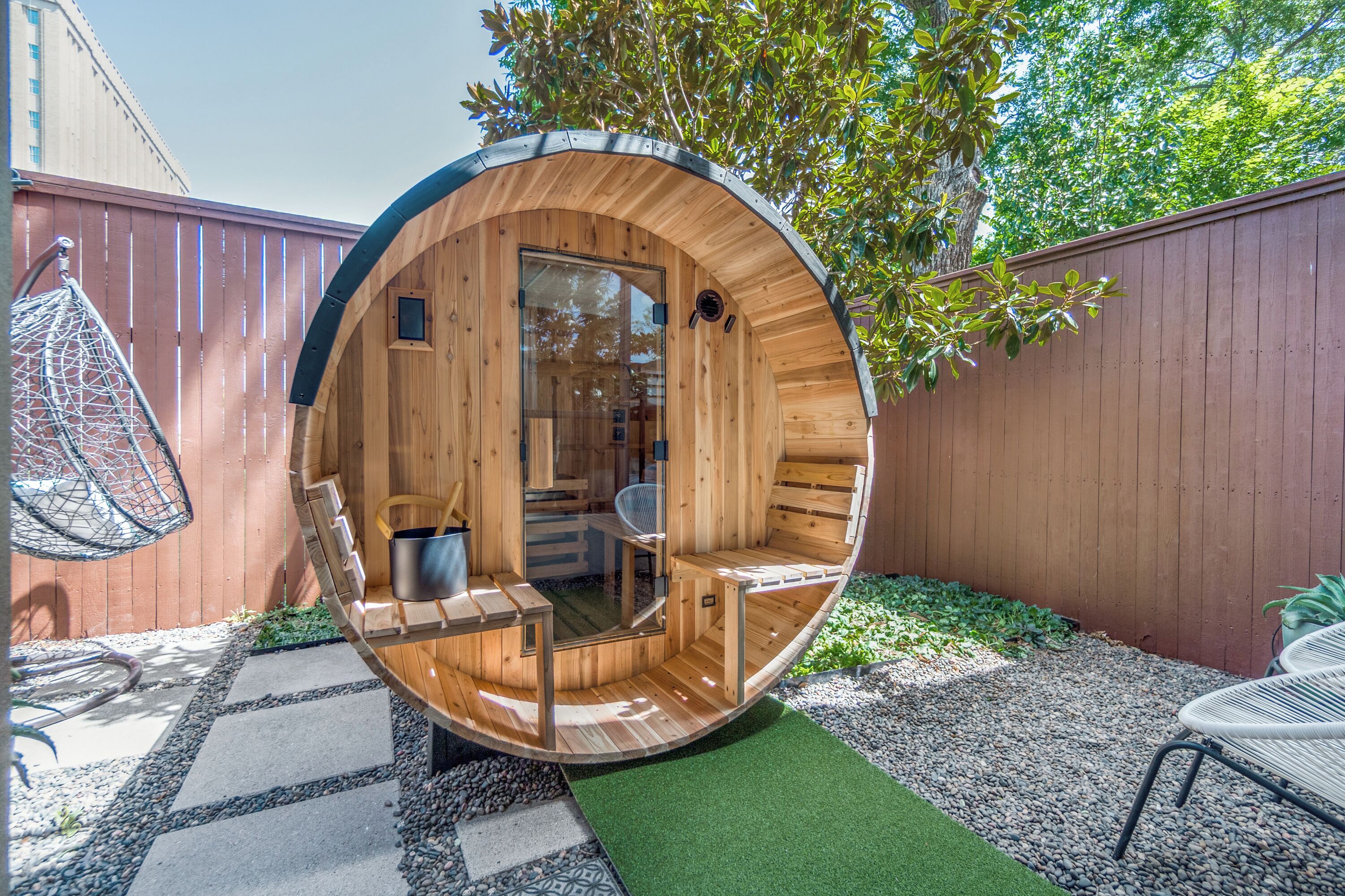 Une structure sphérique en bois, dotée d’une porte en verre, d’un espace salon à l’intérieur et d’une petite table.