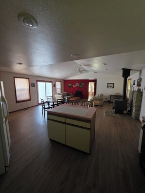 A spacious living area with a dining table, chairs, a sofa, and a kitchen island. - Peaceful Garden Retreat Near Nampa (Nampa)