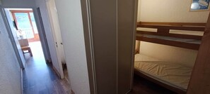 Ein schmaler Flur, der zu einem Raum mit einem Etagenbett führt.