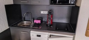 A compact kitchen with a sink, a coffee maker, and a dishwasher. - Le nid des 2 Alpes - Pied de pistes - Hypercentre (Les Deux Alpes)