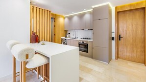 Una cocina moderna con una isla central, electrodomésticos integrados y un revestimiento de pared de madera.