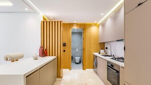 Una cocina moderna con una isla central, electrodomésticos integrados y un separador de madera.