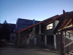 A stone building with a wooden staircase and a metal roof.