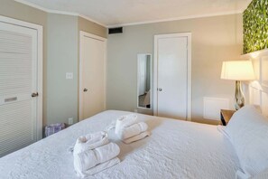 Ein Hotelzimmer mit Bett, Nachttisch, Lampe und Spiegel.