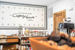 Interior de una cafetería con un letrero grande que dice 'Timberline CoffeeHouse 2026' y una máquina de café.