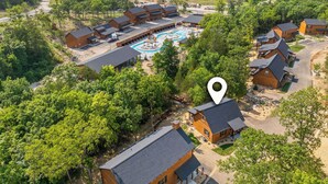A resort with multiple buildings, a swimming pool, and surrounding greenery. - Rustic Log Cabin, 1-Min Walk to Lazy River — Hot Tub, Sleeps 6, Resort Pools (Hollister)