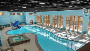 An indoor swimming pool with a slide, lounge chairs, and a hot tub area. - Rustic Log Cabin, 1-Min Walk to Lazy River — Hot Tub, Sleeps 6, Resort Pools (Hollister)