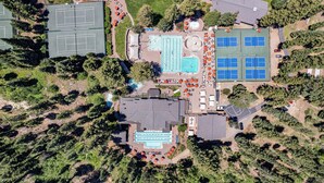 An aerial view of a sports complex with tennis courts, a swimming pool, and a covered area with solar panels. - The Nest at Northstar by Tahoe Getaways - 3BR Walk to Northstar w HOA & Ski Shuttle! (Truckee)