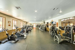 Ein Fitnessraum mit Cardiogeräten, Gewichteinrichtungen und Spiegeln.