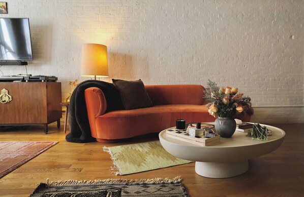 A modern living room with a sofa, a coffee table, a lamp, and a flat-screen TV. - Cozy 1-bedroom apartment in nice Brooklyn with AC (Brooklyn)