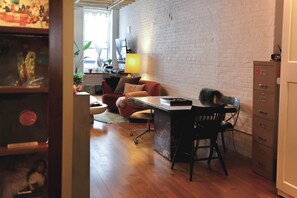 A room with a desk, a chair, a sofa, a lamp, and a filing cabinet. - Cozy 1-bedroom apartment in nice Brooklyn with AC (Brooklyn)