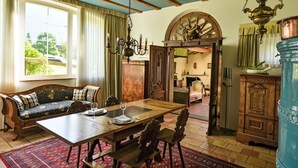 Comedor con una mesa de madera, sillas y un tapete rojo estampado.
