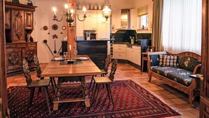 Un interior tradicional con una mesa de comedor de madera, un sofá y una zona de cocina.