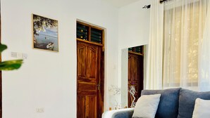 A living room with a sofa, a coffee table, and a door. - Peaceful home at the heart of Kilifi town, with close proximity to the beach (Kilifi)