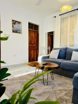 Ein Wohnzimmer mit einer Couch, einem Couchtisch und einer Tür.