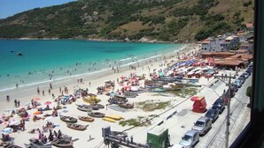 Una spiaggia con barche, ombrelloni e edifici sullo sfondo.