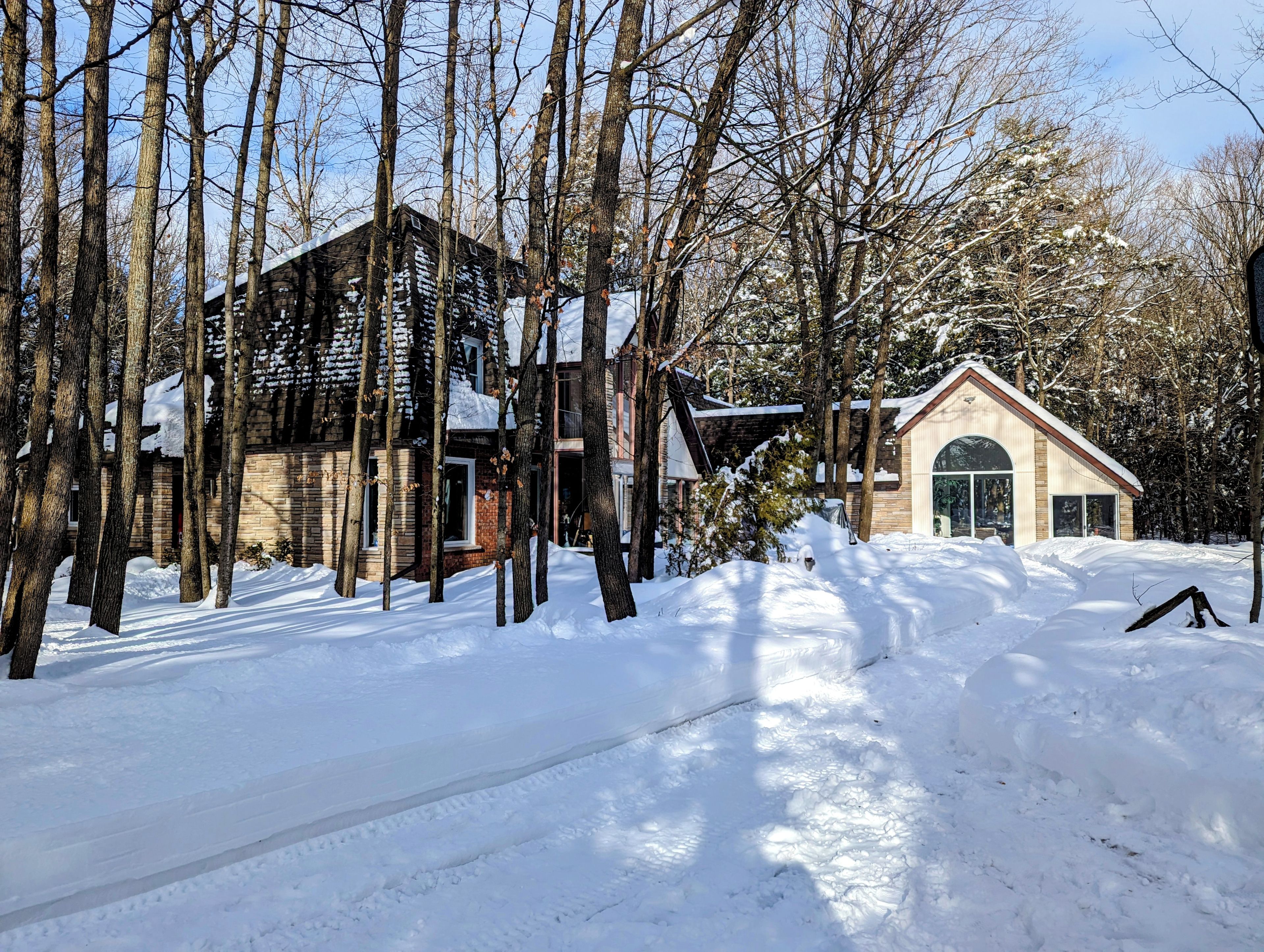 Paisaje nevado con una cabaña de madera y un edificio pequeño con techo a dos aguas.