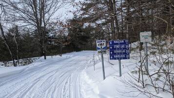 A snow-covered road with directional signs for E107 South and a Havelock tour.