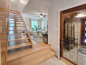 Eine Holztreppe führt zu einem Wohnbereich mit Sofa und Couchtisch.