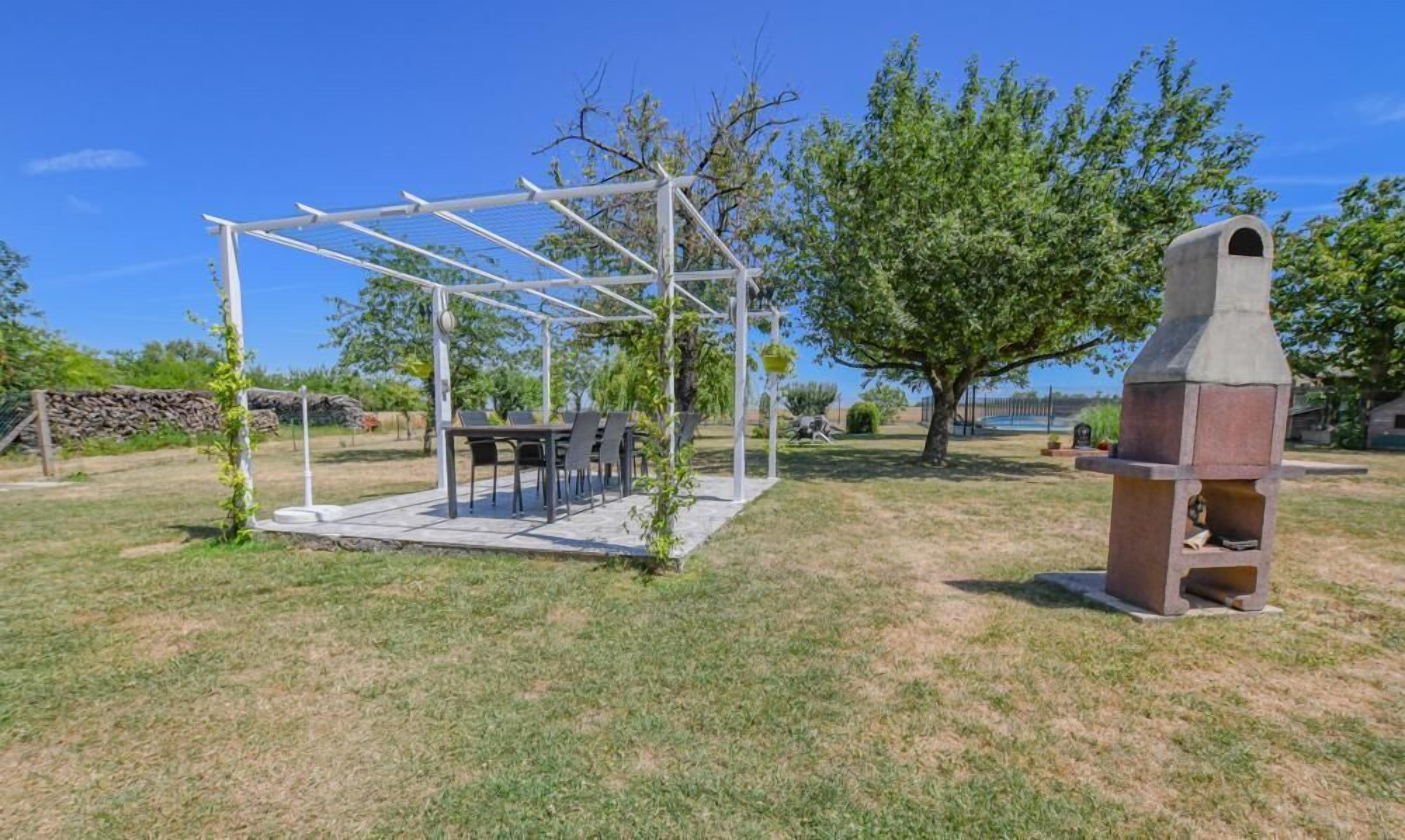 A covered outdoor seating area with a grill and a pergola structure.
