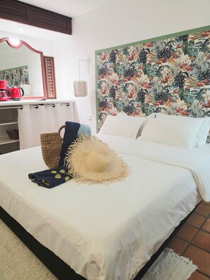A neatly made bed with a straw hat, a woven basket, and a blue towel. - CLEMARA EVASION - Suite Azur  (La Trinité)