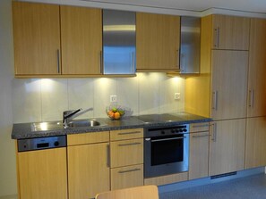 A modern kitchen with wooden cabinets, a stainless steel sink, and a built-in oven. - Domblick Appartement/Fewo 4-Bettwohnung Nr. 2 by Interhome (Saas-Fee)