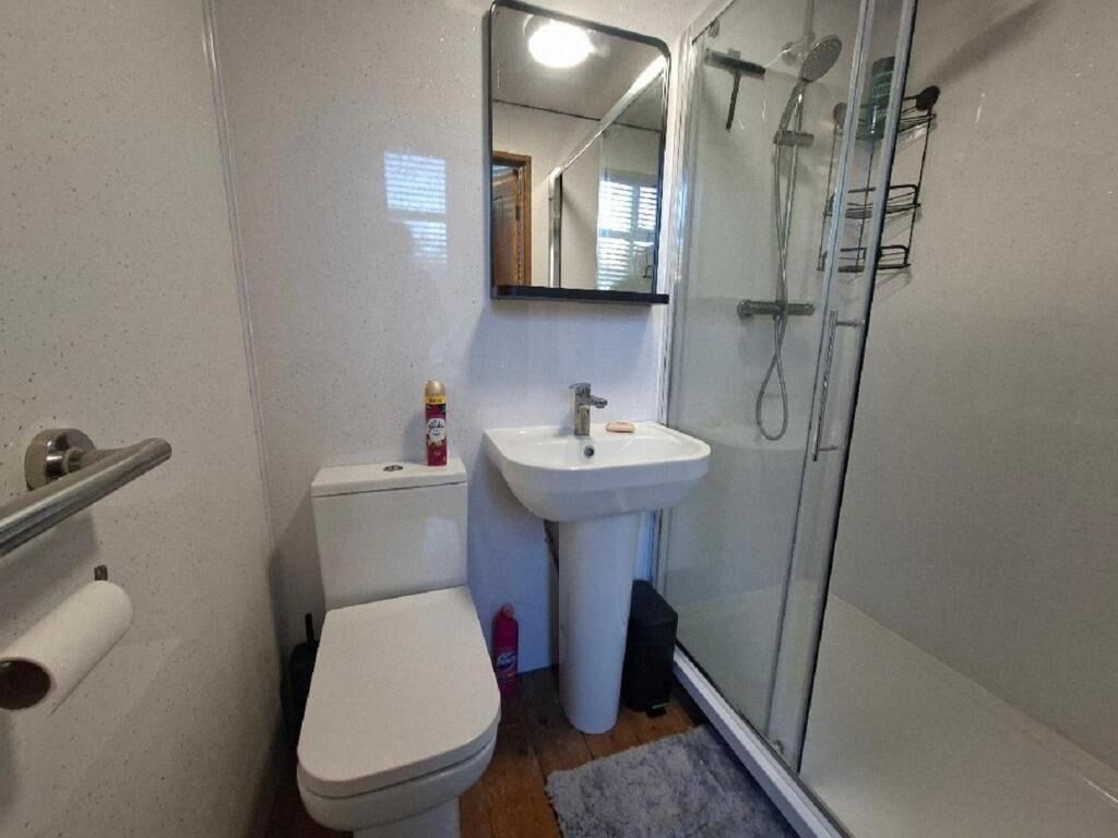 A bathroom with a toilet, sink, and shower.