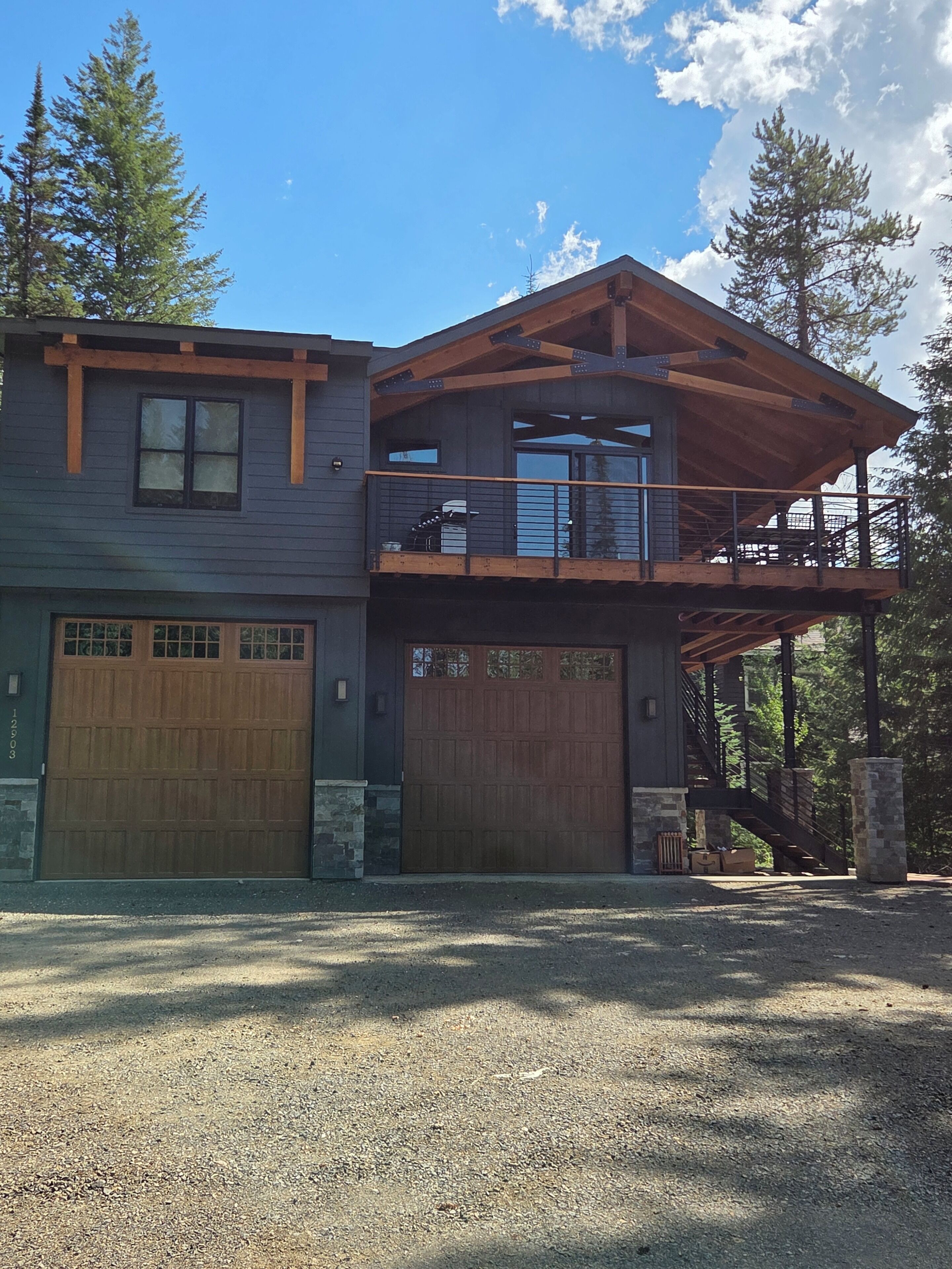 A two-story house with a garage, a balcony, and a staircase leading to the upper level.