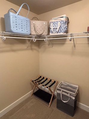 Un placard avec des étagères pour ranger des sacs et un porte-chaussures.