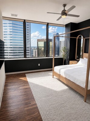 A bedroom with a large window, a ceiling fan, and a bed with a canopy. - Luxury Downtown Dallas Penthouse w/ Rooftop Pool, Gym, Free Parking (Dallas)