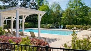 A pool area with a covered seating area and lounge chairs. - 2 Golf Carts☀️ On Raven Golf Course | Heated Pool | Hot Tub | Gym | Beach Gear ☀️Sandestin (Miramar Beach)