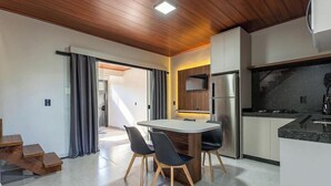 Eine moderne Küche mit Backofen, Kühlschrank und Essbereich mit Tisch und Stühlen.