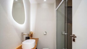 A modern bathroom with a white sink, a mirror, and a glass shower enclosure. - Apt in Condo w/ Pool in Ingleses Norte Ftm0106 (Florianópolis)