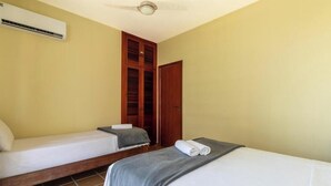 A room with two beds, a ceiling fan, and an air conditioning unit. - Apto in Condo w/ Pool & Ocean View Braga Srb0101 (Cabo Frio)