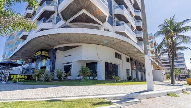 A multi-story building with balconies, a covered entrance, and a sign that reads 'TEMOS CLUB'. - Apto in Condo w/ Pool & Ocean View Braga Srb0101 (Cabo Frio)