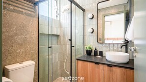 A modern bathroom with a glass shower enclosure, a wooden vanity, and a large mirror. - Studio in Building w/ View Downtown Eva0706 (Florianópolis)