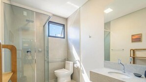 A modern bathroom with a glass shower enclosure, a toilet, and a sink with a mirror. - Studio in Condo w/ Pool Downtown Itapema Ffs0606 (Itapema)